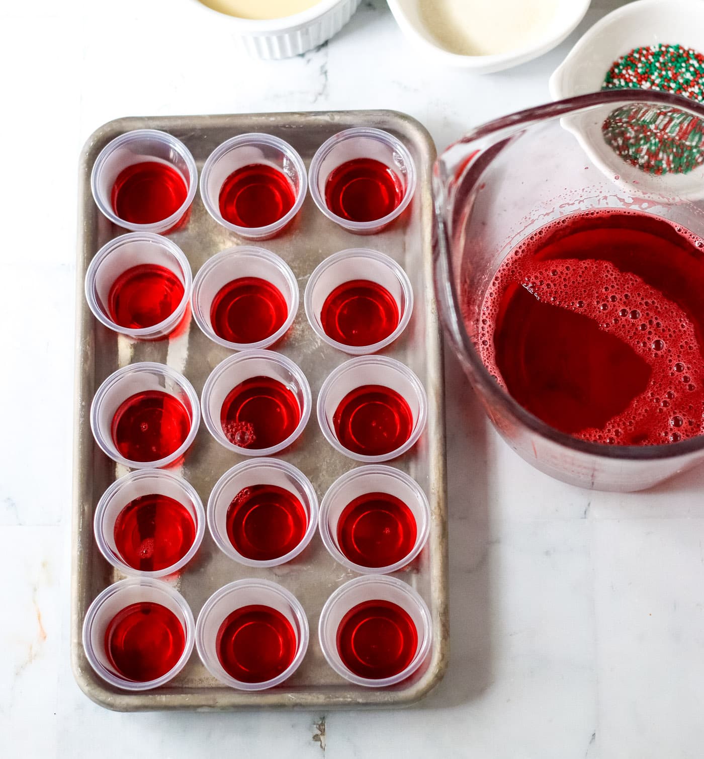 cherry jello in shot glasses on a baking tray