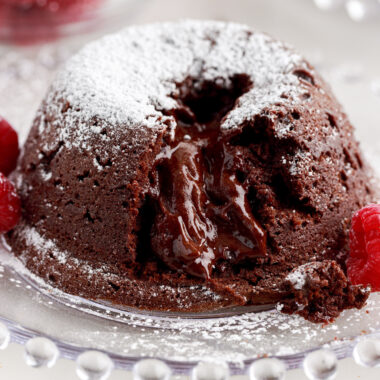 Lava Cake on a plate topped with powdered sugar with a bite taken out