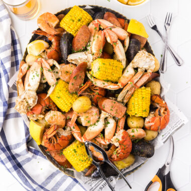 Seafood Boil in a metal serving platter with seafood utensils on the side