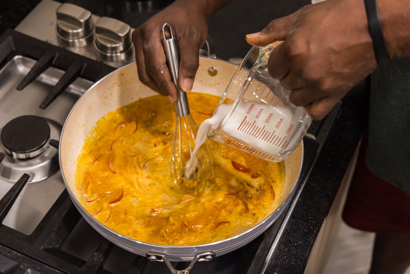 pouring cornstarch slurry into curry