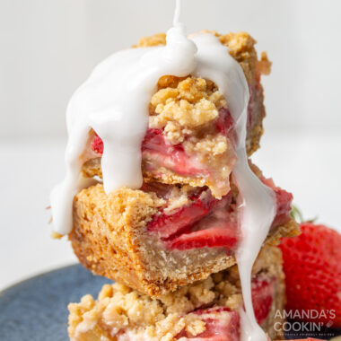drizzle glaze on a stack of strawberry rhubarb crumble bars